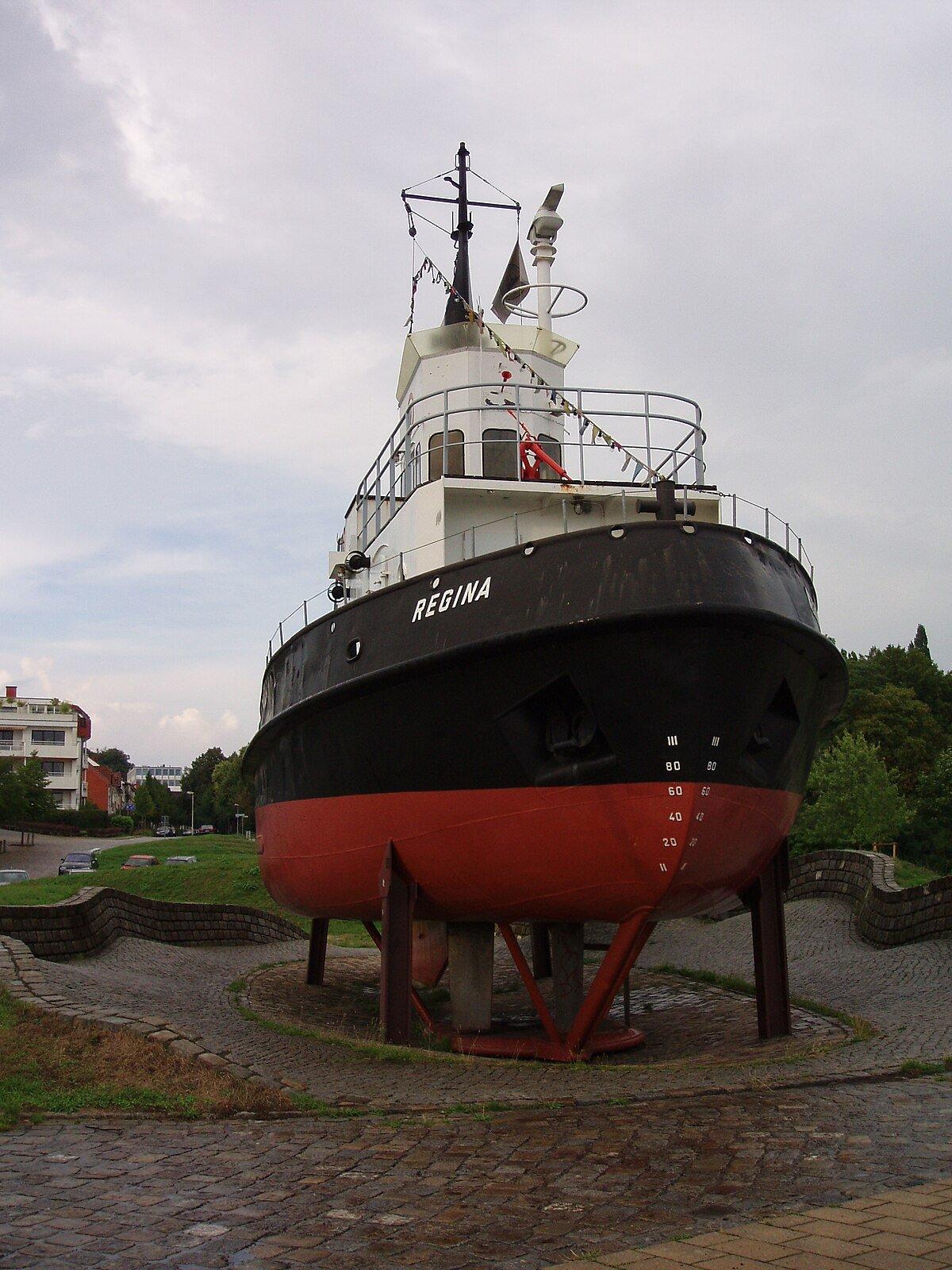 예인선 '레기나(Regina)' 및 선박 프로펠러 조형물 앞